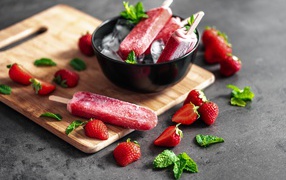 Ягодное мороженое с клубникой и мятой на столе 