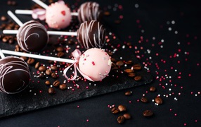 Шоколадные шарики на палочке на столе с кофейными зернами