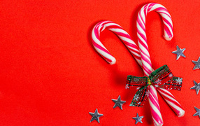 Рождественские леденцы с бантом на красном фоне