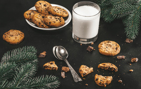 Печенье на столе с молоком и еловыми ветками