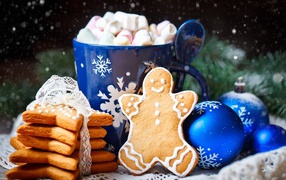 Печенье на столе с чашками и шариками на Новый год 