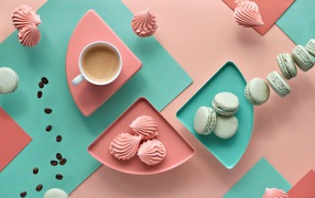 Чашка какао на столе с зефиром и десертом макарон 