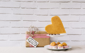 Кексы на тарелке на столе с подарком для любимой 