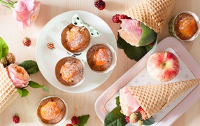 Вкусные кексы с абрикосом на столе с вафельными рожками с розой и ежевикой