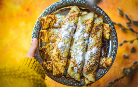 Вкусные тонкие блины с сахарной пудрой на блюде