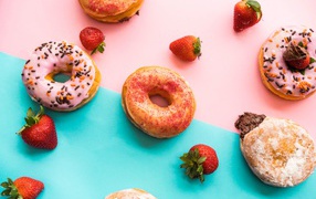 Пончики с глазурью на столе с ягодами клубники