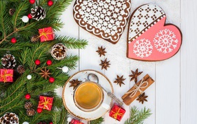 Печенье в форме сердца на столе с чашкой кофе и еловой веткой