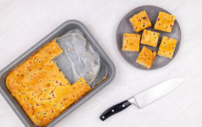 Пирог нарезан кусочками на столе с ножом