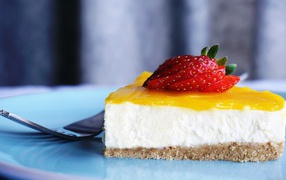 Кусок чизкейка с кремом и спелой клубникой 
