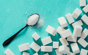 Кусочки сахара рафинада на голубом столе