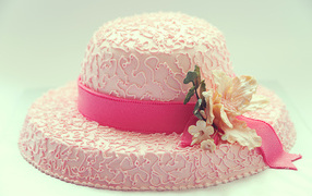 Розовый торт в виде шляпы на столе 