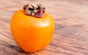 Спелая оранжевая хурма на столе