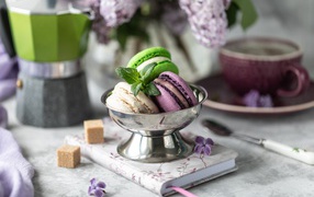 Три печенья макарун на столе с блокнотом