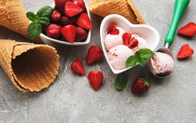 Вафельные рожки на столе с фруктовым мороженым и ягодами клубники 