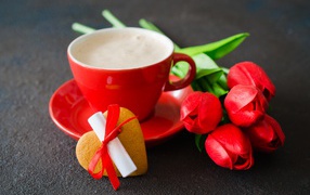 Букет тюльпанов и чашка кофе с печеньем на столе