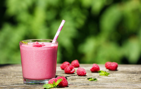 Коктейль в стакане с трубочкой и ягодами малины