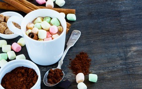 Кофе с маршмеллоу на столе с корицей и сахаром