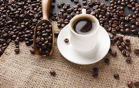 Чашка кофе на столе с зернами 