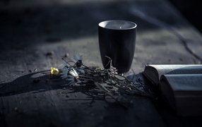 Чашка чая на столе с ромашками и книгой 