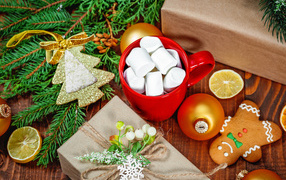 Чашка с маршмеллоу на столе с подарком, печеньем и еловой веткой