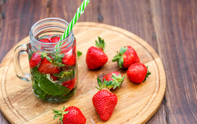 Напиток  в банке с ягодами клубники и трубочкой
