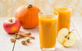 Свежевыжатый сок в стаканах на столе с фруктами