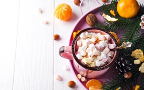 Кружка с маршмеллоу на столе с мандаринами