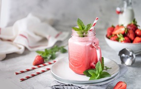 Смузи с клубникой в банке с трубочкой и листьями мяты