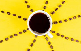 Солнце из чашки кофе с зернами на желтом фоне