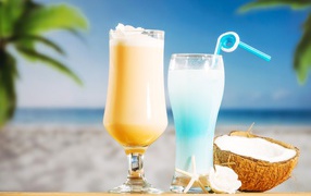 Два коктейля с кокосом на столе на тропическом пляже