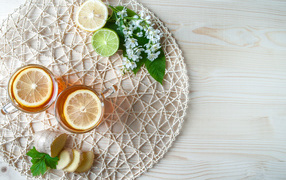 Две чашки чая с лимоном на плетеной подставке 