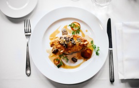 Кусок жареного мяса на большой белой тарелке 