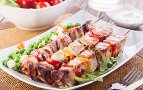 Аппетитный шашлык на тарелке с горохом