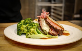 Брокколи на тарелке с кусочками запеченного мяса 