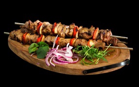 Вкусный шашлык на доске с луком и зеленью 