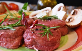 Свежее мясо маринуется со специями на столе с грибами