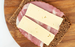 Бутерброд с ветчиной и сыром на доске 