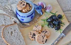 Колбаса с маслинами на столе с хлебом и чесноком