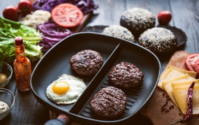 Три котлеты на сковородке с яичницей