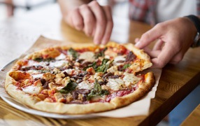 Мужчина в кафе ест вкусную горячую пиццу 