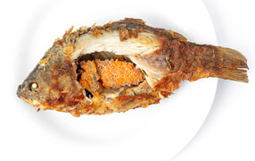 Жареная рыба с икрой внутри на белом фоне
