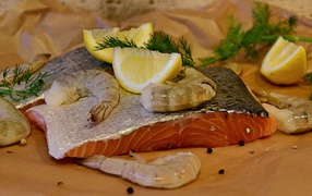 Кусок красной рыбы с креветками и лимонами