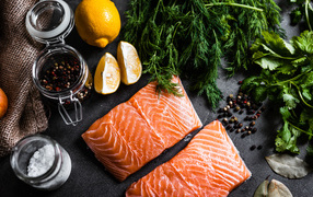 Куски красной рыбы на столе с зеленью и специями 