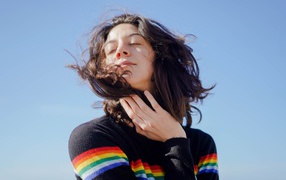 Молодая девушка греет лицо на солнце