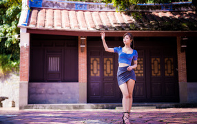 Девушка азиатка в короткой юбке у здания 