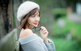 Девушка азиатка в очках и теплом свитере