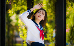 Девушка азиатка в форме с красным галстуком