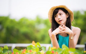 Девушка азиатка с часами на руке в шляпе