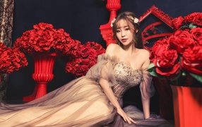 Азиатка в красивом платье в комнате с красными цветами
