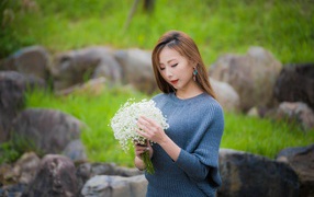 Красивая девушка азиатка держит в руках букет белых цветов